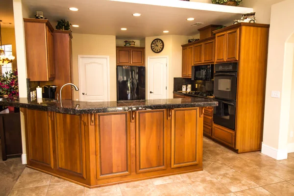 Cocina con mostradores de granito y gabinetes de grano de madera rica — Foto de Stock