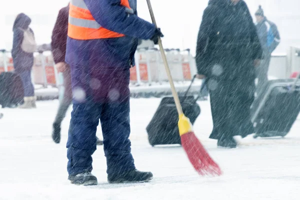 Bir adam kar yoldan temizler.