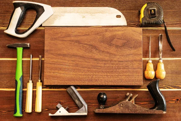 Ahşap arka plan üzerinde farklı marangoz araçları.