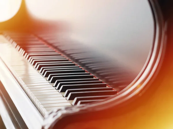Closeup view of classical piano keys with warm tones.