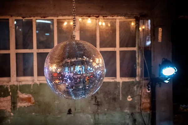 Aynalı küreyi eski duvarlar ve Windows arka plan tavanda altında.