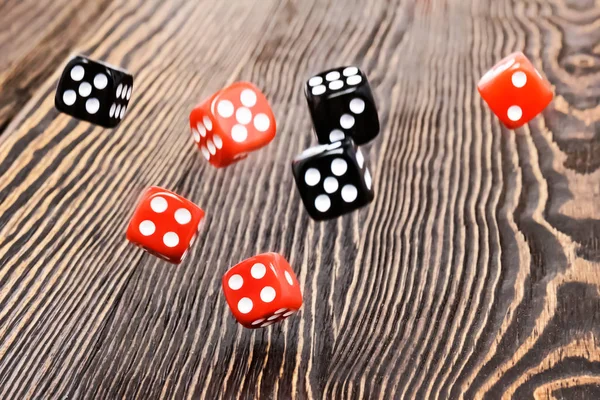 Playing dice in the game over a wooden table, a game of roulette. The concept of gaming addiction, entertainment.