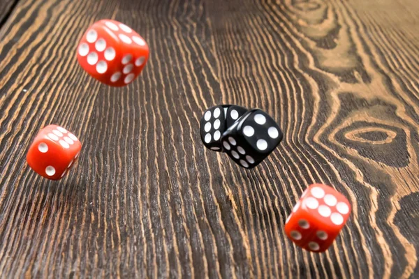 Playing dice in the game over a wooden table, a game of roulette. The concept of gaming addiction, entertainment.