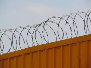 Dikenli tel rulo bir metal kapı üzerine yerleştirilen