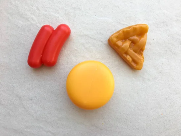 Assorted plastic toy food on light background