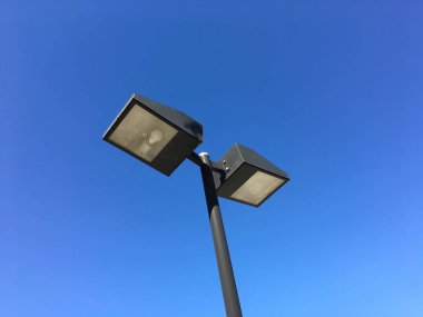 Mavi gökyüzüne tarafından çerçeveli bir metal lamba sonrası