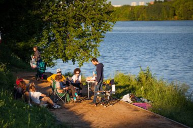 Moskova, Rusya, 21 Haziran 2020: Gençler nehir kenarında piknik yapıyorlar