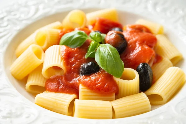 Maccheroni Mit Tomatensauce Oliven Und Frischen Basilikumblättern lizenzfreie Stockbilder