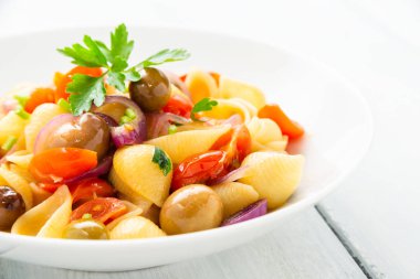 domates, soğan, zeytin, zeytinyağı ve maydanoz ile İtalyan kabuk makarna yemeği 