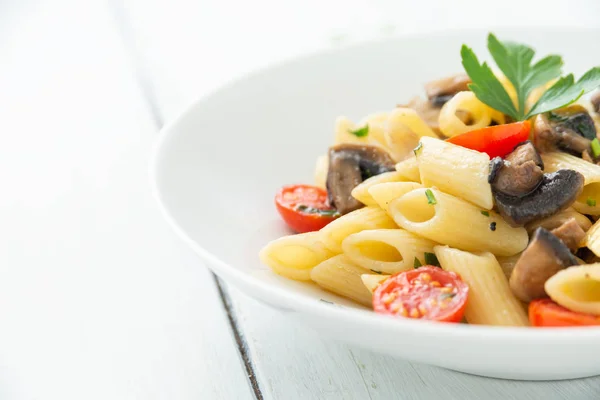 stock image Dish of penne pasta with mushrooms and cherry tomatoes, mediterranean food 