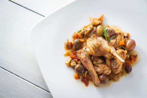 Dish of stewed rabbit meat with delicious olive and carrot sauce, italian food