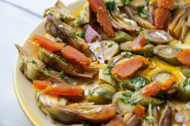 Dilimlenmiş bottarga ve taze enginar, tipik sardalya mezesi.