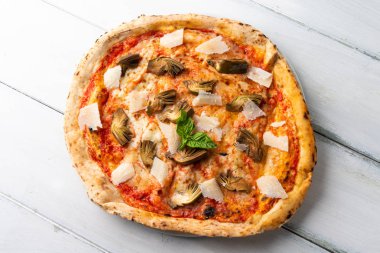 Dilimlenmiş enginarlı ve parmesanlı lezzetli pizza.