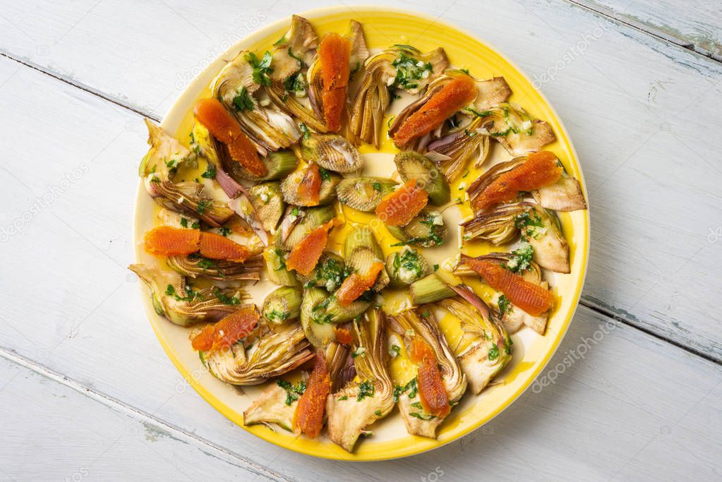 Dish of sliced bottarga and fresh artichokes, typical sardinian appetizer