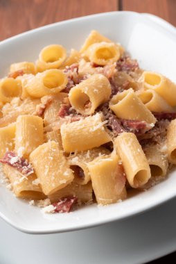 Dish of delicious pasta alla gricia, typical italian recipe of pasta with guanciale and pecorino romano clipart
