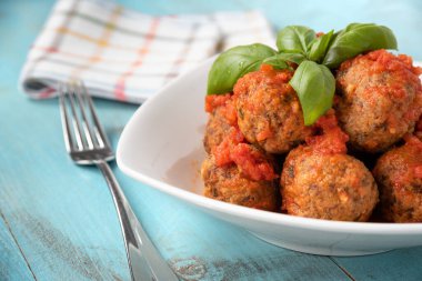 Bir tabak lezzetli köfte, domates sosu ve taze fesleğen. 