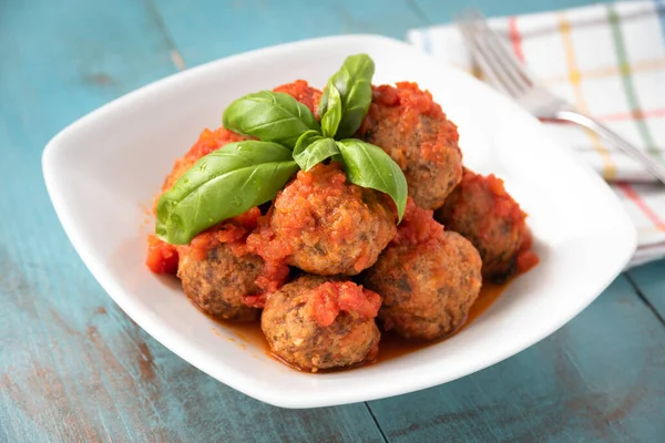 Bir tabak lezzetli köfte, domates sosu ve taze fesleğen. 