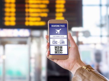 Biniş kartı içinde hareket eden telefon. Havaalanında ekranda modern bilet ile Smartphone tutan kadın. Uçak için kolay ve hızlı erişim. Terminal ve bulanık arka planda Uçus tarifesi.