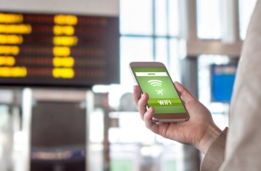 Havaalanı wifi. Ücretsiz kablosuz internet bağlantısı terminal. Örümcek ağı browsing ve gidiş daha önce online gidiş kadın. El tutma cep telefonu. Takvim ve zamanlama arka plan bulanık.