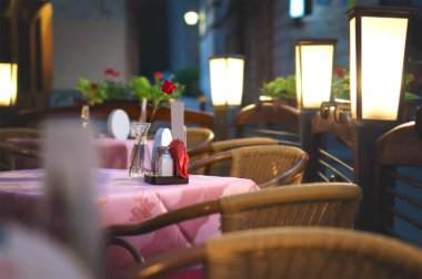 Restoran yemek masası için romantik tarih bekliyor. Ortam aydınlatma boş açık teras.