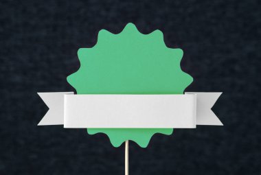 Yeşil şekilli daire üzerinde tahta bir sopa karton kesme. Yuvarlak kağıt rozet, etiket, işaret, veba veya tasarım öğesi ile koyu gri arka plan ve boş boş kopya alanı şablonu için. El sanatları afiş.