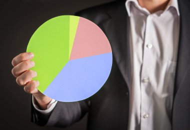Karton kağıttan yapılmış bir pasta grafiği holding iş adamı. Görsel gösteri finans istatistikler ve Pazar ve satış durumu.