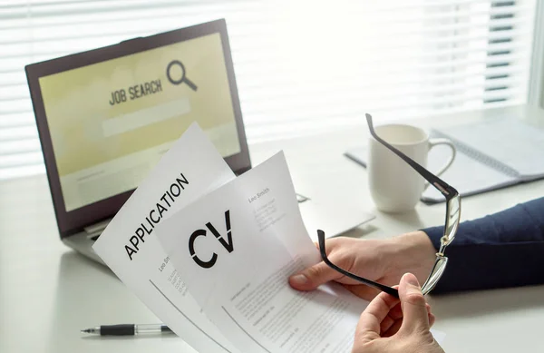 Job seeker in home office. Motivated applicant. Modern job hunting, seeking and employment. Man reading his cv or curriculum vitae and job application paper and trying to find work and get hired.