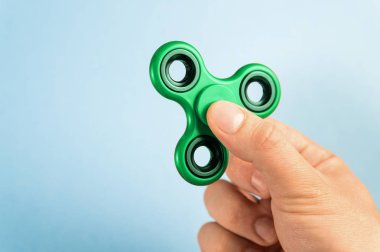 Mavi arka plan karşı parmakları arasında Spinner kıpır.