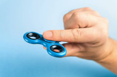 Mavi topluca spinner parmak arasında