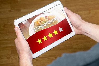 İyi Restoran İnceleme memnun ve mutlu müşteri ve gözden geçiren. Dört beş yıldızla derecelendirilen. Tablet hayali eleştiri uygulama, sosyal medya veya Web sitesi ile ekranda holding eller.