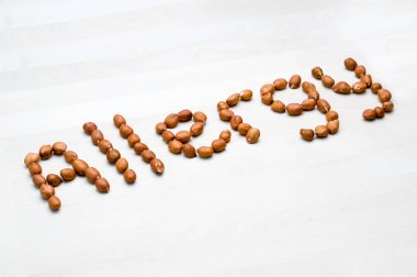 Anti fıstık ile yazılmış. Word ve fındık yapılan metin. Beyaz ahşap masa veya Yönetim Kurulu yer fıstığı. Alerjik reaksiyon ve beslenme sorunu kavramı.