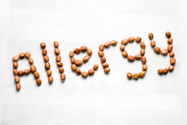 Anti fıstık ile yazılmış. Word ve fındık yapılan metin. Beyaz ahşap masa veya Yönetim Kurulu yer fıstığı. Alerjik reaksiyon ve beslenme sorunu kavramı. En iyi açılı görünüş.