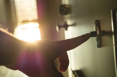 Parmak basarak kapı zili güneşli apartman koridorda. Daireler bir blok içinde kapı zili çalmayı el kapatın. Güneş ışığı ve hafif sızıntı penceresinden geliyor. Mutlu, yaz ve pozitif hissetmek.