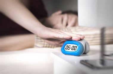 Adam sabah işe için uyandırmak istemiyorum. Çalar saat veya basın erteleme düğmesi el ile devre dışı bırakarak. Tembel kişi yataktan kalkmak yapamaz. Kötü Pazartesi. Kalkmak için çok erken.