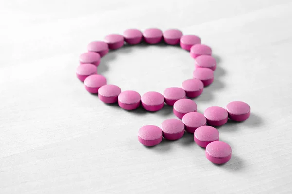 女人的药 更年期 Pms 月经或雌激素的概念 女性健康 在木桌上用粉红色的红药丸或片剂制作的性别符号 — 图库照片