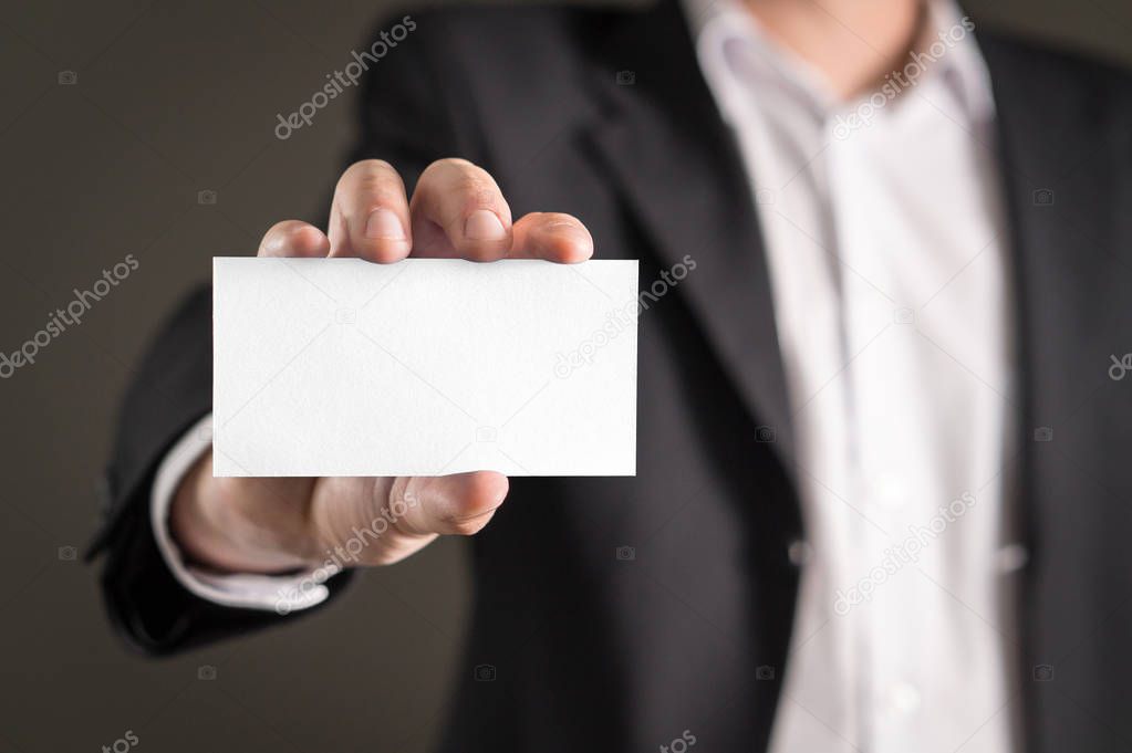 Business man holding empty white business card.