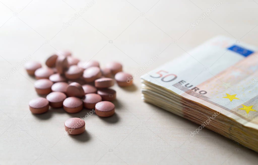Medical business or prices concept. Making money in pharmaceutical industry or high medical expenses. Also drug dealing, dealer or trade. Pills, medicine, tablets and 50 euro bills and money on table.
