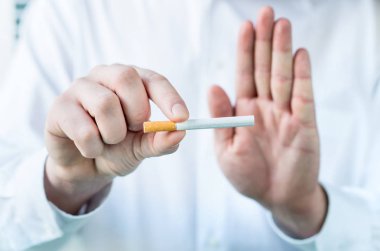 Sigarayı bırakmak için söylüyor Doktor. Sigara parmakları arasında tutarak ve eliyle dur işareti gösterilen.
