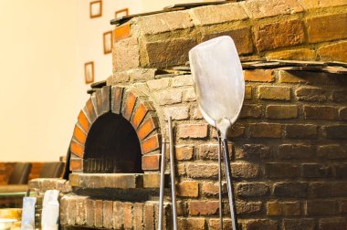 Geleneksel tuğla fırın. Eski bir mutfak taş karşı yaslanmış pizza küreği.