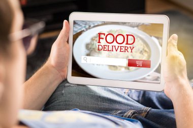 Gıda teslim app tablet. Evde online restorandan sipariş yapmak için akıllı aygıt kullanan adam. Ekranda hayali uygulama, Web sitesi ve internet mağaza.