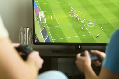 İki adam hayali multiplayer futbol ya da futbol video oyun konsolu ve tv oynuyor. Çocuklar gece, parti ve hafta sonu kavramı.