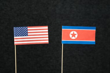 Amerika Birleşik Devletleri (ABD) ve Kuzey Kore bayrağı kağıt ahşap çubuk koyu arka plan üzerinde yapılan.