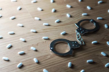 Uyuşturucu bağımlılığı, tıp istismarı ve uyuşturucu kanca ve bağımlılık kavramı. Kelepçeler çok hap var ki tarafından çevrili. Tablet aşırı dozda. Yoksunluk belirtileri, depresyon ve sorun.