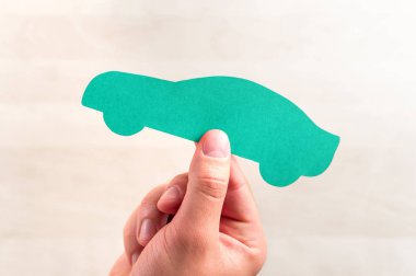 Araç satış veya kredi, otomatik sigorta, sürüş okulu ya da araç muayene ve kavram işaretleyiniz. Yeni veya kullanılmış otomobil satın alma. Bir karton kağıt şekli tutan el.