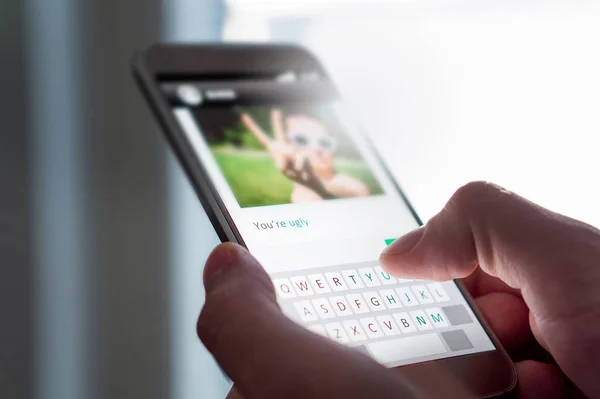 Cybermobbing, Internet-Trolling und schlechtes Online-Verhalten. Person schreibt miesen Kommentar zu Bild auf einer imaginären Social-Media-Website mit Smartphone. — Stockbild Cybermobbing Internet Trolling Und Schlechtes Online Verhalten Person Schreibt Miesen — Stockfoto