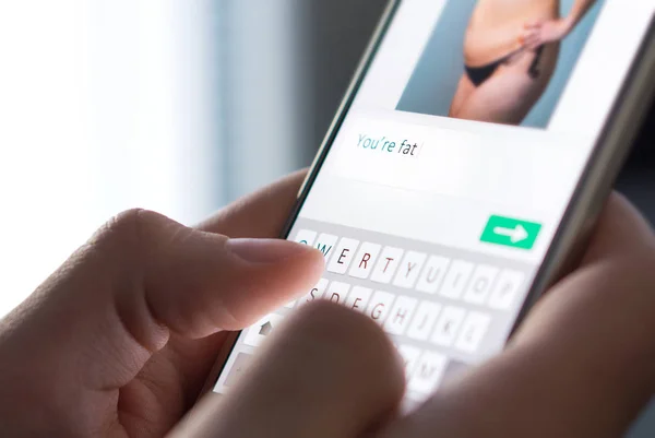 Körperscham, Cyber-Mobbing und schlechtes Verhalten im Internet. Internet-Troll verschickt fiesen Kommentar zu Bild auf imaginärer Social-Media-Website mit Smartphone. — Stockbild Körperscham Cyber Mobbing Und Schlechtes Verhalten Internet Internet Troll Verschickt — Stockfoto