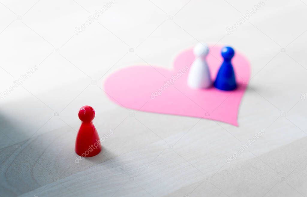 Having affair, infidelity or cheating concept. Love triangle or being third wheel. Board game pawns and paper heart on table.