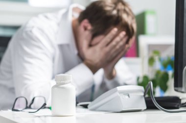 Doktor kapak yüz baskı altında vurguladı. Üzgün hemşire, yorgun hekim ya da uygulanacağı belge Doktor üzgün hastane ofiste ağlıyor. Yolsuzluk, tedavi hata ve hata veya ihmal. İşyerinde zorbalık.