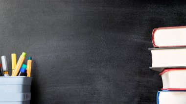 Eğitim ve öğrenme blackboard, kalem, kitap yığını ile arka plan. Geri okul ve sınıf kavramı kopya alanı ile. Kaba kara tahta doku.