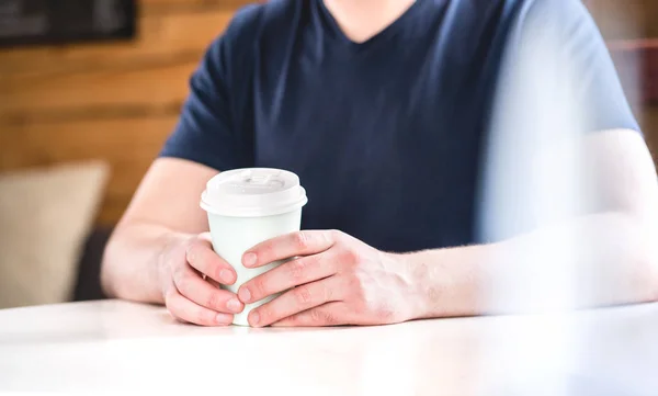 カフェ コーヒー ショップや自宅でテーブルの上の手でコーヒー カップを奪うを抱きかかえた ホット チョコレートや紅茶を持つ男 — ストック写真